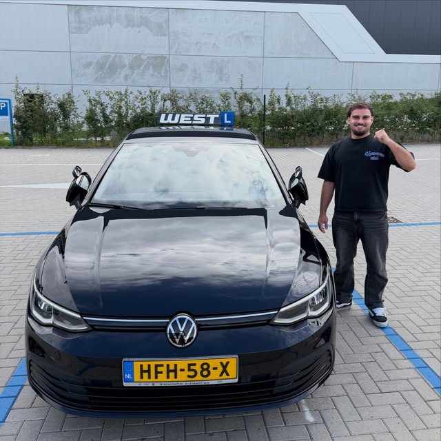 Geslaagde leerling viert zijn rijbewijs naast de WEST-lesauto