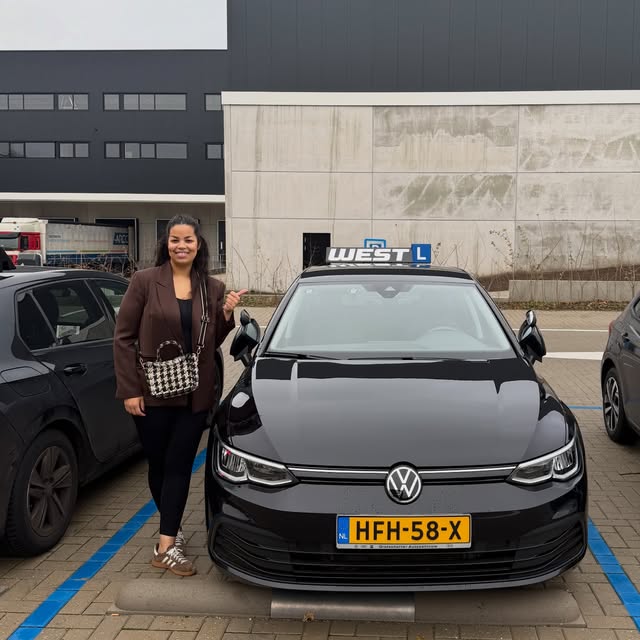 Geslaagde leerling geeft een duim omhoog bij de WEST-lesauto